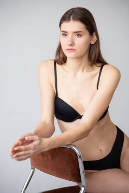 Stüdyoda poz veren siyah iç çamaşırlı güzel bir esmer.