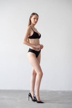 Stüdyoda poz veren siyah iç çamaşırlı güzel kız.