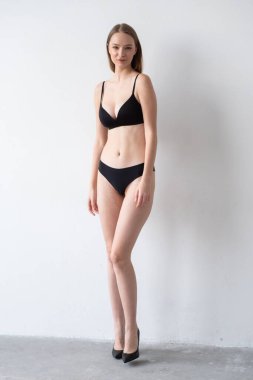 Genç kadın stüdyoda poz siyah iç çamaşırı