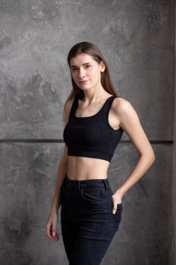 Siyah bluzlu ve kot pantolonlu güzel bir kızın portresi.