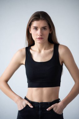 Gri arka planda uzun saçlı güzel bir kadının stüdyo çekimi.