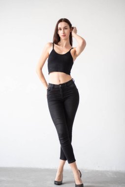 young beautiful woman in black clothes posing in studio