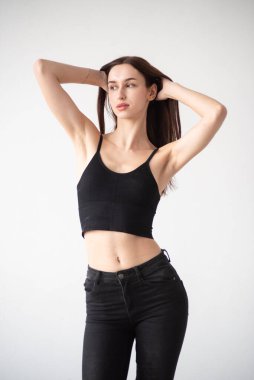 Siyah t-shirt ve kot giyen genç esmer manken.