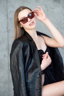 Güneş gözlüklü ve deri ceketli güzel bir manken.