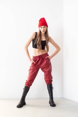 Güzel kadın kırmızı beyaz pantolonla poz veriyor.