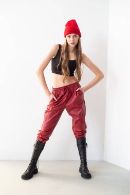 Beyaz arka planda kırmızı eşofmanlı genç bir kız.