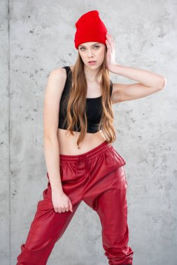 Stüdyoda gri arka planda şapkalı güzel bir kadın.