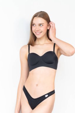 Basit siyah iç çamaşırlı, taze yüzlü bir mankenin görüntüsü. Doğal özelliklerini, vücut oranlarını ve kendine güvenen duruşunu vurguluyor. Ajans keşifleri ve profesyonel portföy güncellemeleri için ideal