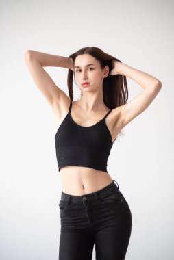 Genç kız stüdyoda, siyah arka planda.