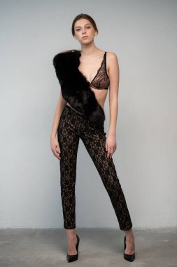 Kürklü genç bir kadın stüdyoda poz veriyor.