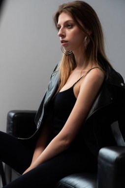 Genç kadın sandalyede oturuyor.