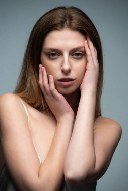 Doğal makyajlı bir kadın. Stüdyoda, karanlık bir zeminde.