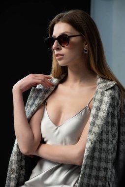 Şık bir ceket ve güneş gözlüğü takmış güzel seksi bir kız. Güzellik ve tarz.