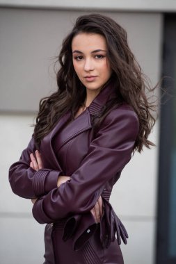 Deri ceketli, şehrin sokaklarında poz veren güzel esmer kız..