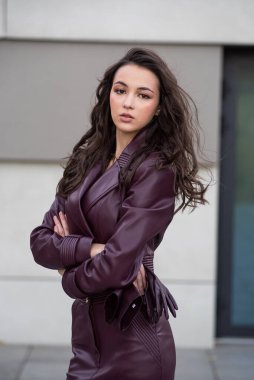 Gri arkaplanda gri ceketli güzel bir genç kız..