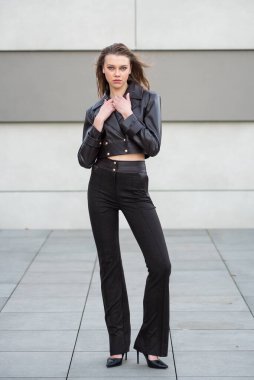 Deri ceketli ve siyah pantolonlu güzel bir esmer..