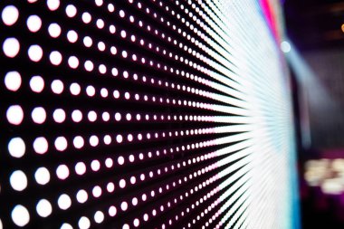 Elektronik müzik konserinde veya gece partisi etkinliğinde parlayan piksellerin ve dinamik sahne ışıklandırmasının soyut arka planında dijital ekranda renkli LED ışıkları