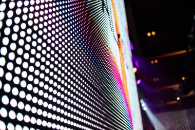 Elektronik müzik konserinde veya gece partisi etkinliğinde parlayan piksellerin ve dinamik sahne ışıklandırmasının soyut arka planında dijital ekranda renkli LED ışıkları