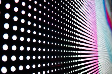 Elektronik müzik konserinde veya gece partisi etkinliğinde parlayan piksellerin ve dinamik sahne ışıklandırmasının soyut arka planında dijital ekranda renkli LED ışıkları