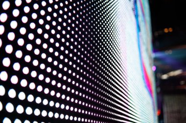 Elektronik müzik konserinde veya gece partisi etkinliğinde parlayan piksellerin ve dinamik sahne ışıklandırmasının soyut arka planında dijital ekranda renkli LED ışıkları