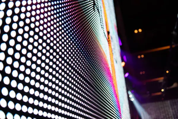 Elektronik müzik konserinde veya gece partisi etkinliğinde parlayan piksellerin ve dinamik sahne ışıklandırmasının soyut arka planında dijital ekranda renkli LED ışıkları