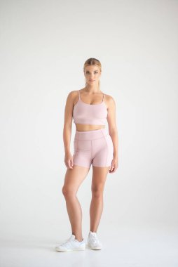 Stüdyoda duran spor elbiseli kadın.