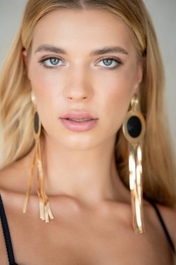 Makyajlı ve küpeli güzel sarışın kadına yaklaş.