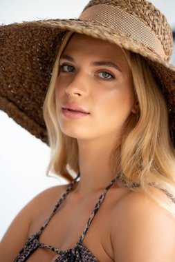 Plajda şapkalı genç bir kadının portresi..