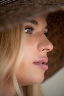 Bahçede şapkası ve makyajı olan güzel sarışın kadın.