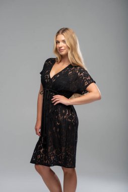 Beyaz arka planda siyah elbiseli sarışın model