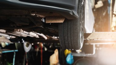 Arabadaki tekerlek ve garajdaki farklı ekipmanlar..