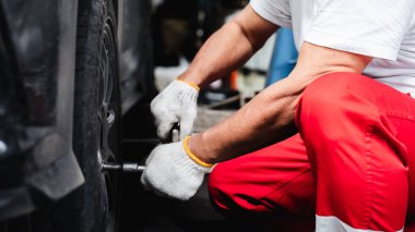 Garajda İngiliz anahtarı tutan tamirci eliyle yakın çekim..