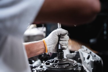 Oto tamirhanesinde, tamirciler ortaya çıkabilecek her türlü sorunu çözmek için otomobil motorlarının tamiri ve bakımı üzerinde çalışıyorlar..