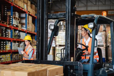 Warehouse workers with a forklift working  in the warehouse., Industrial and industrial concept.