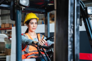 Portrait of a female worker with a forklift in the warehouse., Industrial and industrial concept.