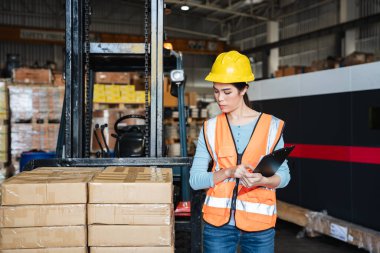 Warehouse worker checking the quantity of storage products on the shelf  in the warehouse., Industrial and industrial concept.