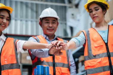 Group warehouse workers raise their hands to celebrate and be happy in the warehouse., Industrial and industrial concept.