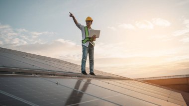 Servis mühendisi hasar görmüş bir parça var mı diye çatıdaki güneş hücresini kontrol ediyor. Mühendis işçisi güneş paneli kuruyor. Temiz enerji kavramı.