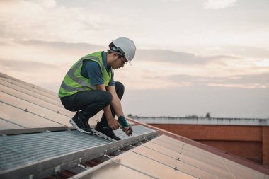 Servis mühendisi hasar görmüş bir parça var mı diye çatıdaki güneş hücresini kontrol ediyor. Mühendis işçisi güneş paneli kuruyor. Temiz enerji kavramı.