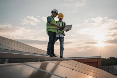 Servis mühendisi hasar görmüş bir parça var mı diye çatıdaki güneş hücresini kontrol ediyor. Mühendis işçisi güneş paneli kuruyor. Temiz enerji kavramı.