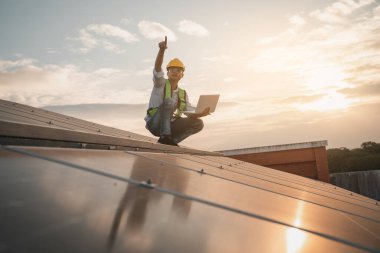 Servis mühendisi hasar görmüş bir parça var mı diye çatıdaki güneş hücresini kontrol ediyor. Mühendis işçisi güneş paneli kuruyor. Temiz enerji kavramı.