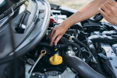 Genç adam arabasını kontrol ediyor. Araba tamiri ve bakım konsepti. 