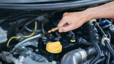 Delikanlı arabasının motor kalitesini kontrol ediyor. Araba tamiri ve bakım konsepti. 