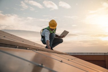 Servis mühendisi hasar görmüş bir parça var mı diye çatıdaki güneş hücresini kontrol ediyor. Mühendis işçisi güneş paneli kuruyor. Temiz enerji kavramı.