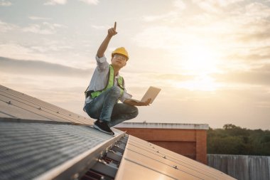 Servis mühendisi hasar görmüş bir parça var mı diye çatıdaki güneş hücresini kontrol ediyor. Mühendis işçisi güneş paneli kuruyor. Temiz enerji kavramı.