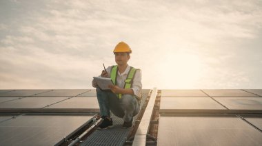 Servis mühendisi hasar görmüş bir parça var mı diye çatıdaki güneş hücresini kontrol ediyor. Mühendis işçisi güneş paneli kuruyor. Temiz enerji kavramı.