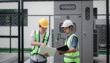Mühendisler elektrik santralini inceledi ve operasyonel voltaj aralığını doğruladı. Teknisyen voltaj şalterini denetliyor..