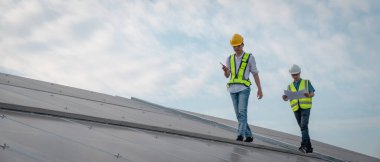 Servis mühendisi hasar görmüş bir parça var mı diye çatıdaki güneş hücresini kontrol ediyor. Mühendis işçisi güneş paneli kuruyor. Temiz enerji kavramı.