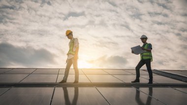 Servis mühendisi hasar görmüş bir parça var mı diye çatıdaki güneş hücresini kontrol ediyor. Mühendis işçisi güneş paneli kuruyor. Temiz enerji kavramı.