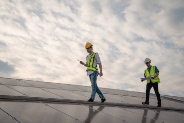 Servis mühendisi hasar görmüş bir parça var mı diye çatıdaki güneş hücresini kontrol ediyor. Mühendis işçisi güneş paneli kuruyor. Temiz enerji kavramı.